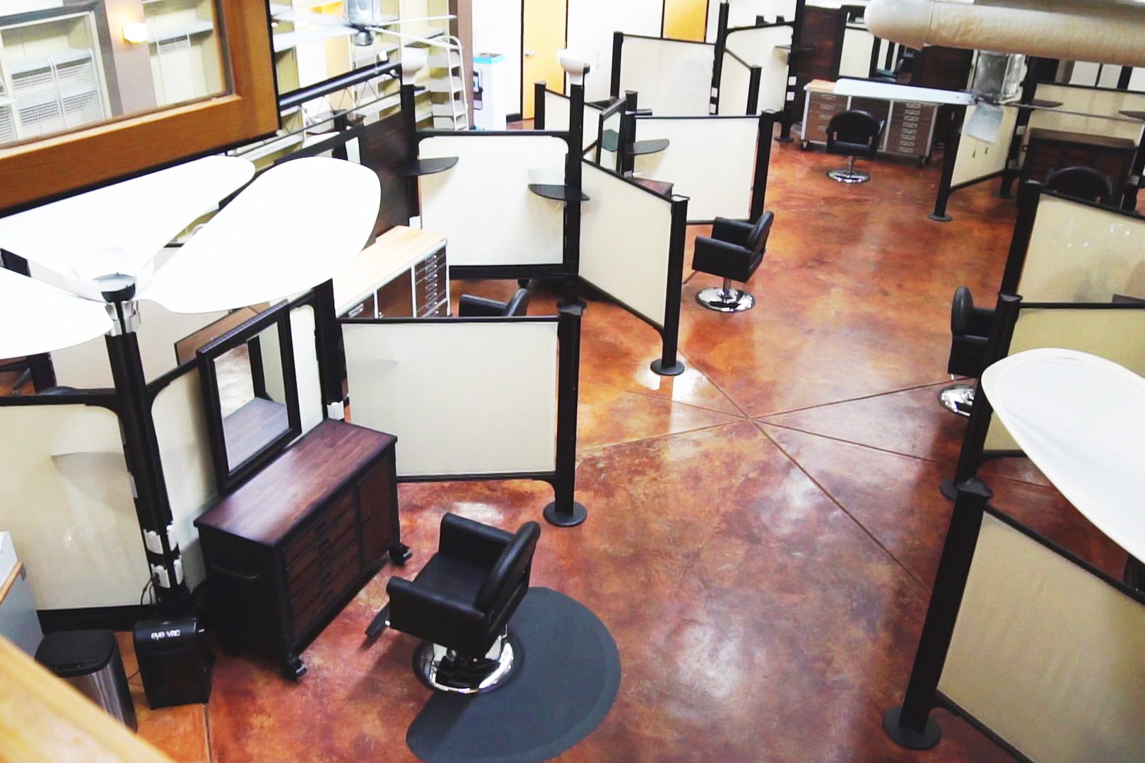 A barber shop with many chairs and tables.
