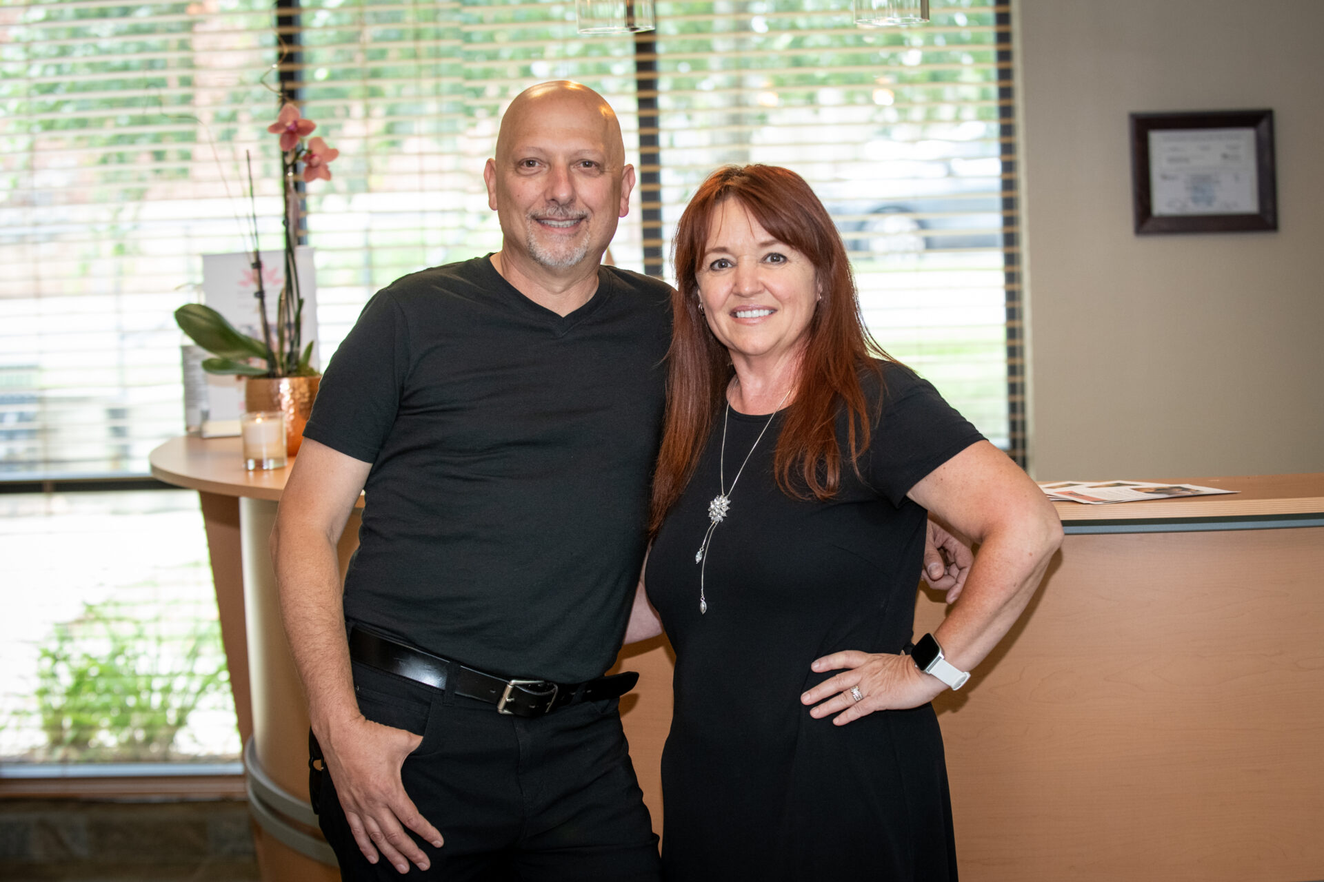 man and woman stantding in front of window wearing black