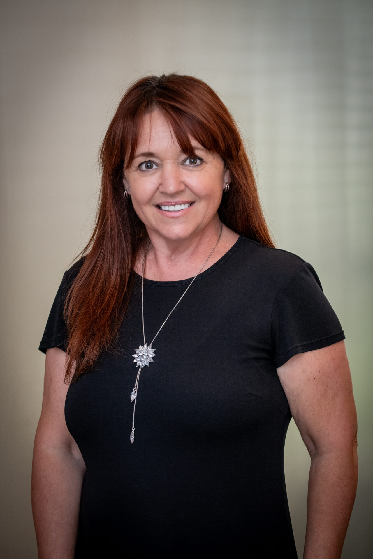 woman standing with black shirt and long red hair