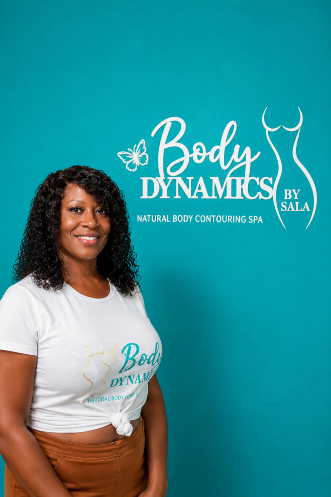 woman smiling and standing in front of body dynamics logo